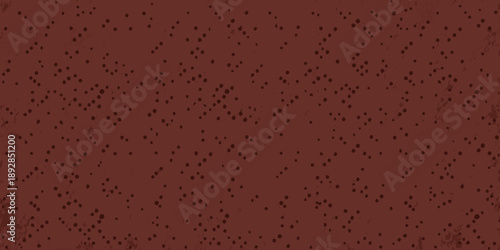 Abstract reddish brown background with scattered dark speckles and granular texture