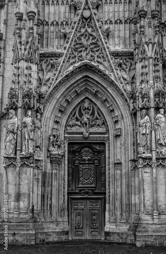 Close-up of a monumental church doorway with sculpted stone figures and ornate carvings on a Church, Gothic architecture detail.