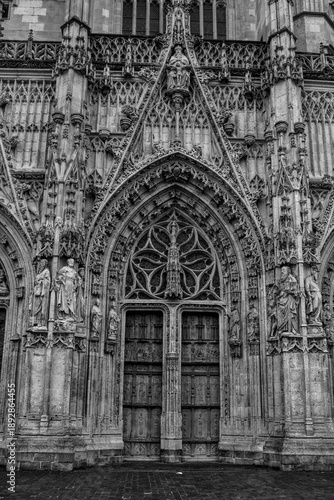 Close-up of a monumental church doorway with sculpted stone figures and ornate carvings on a Church, Gothic architecture detail.