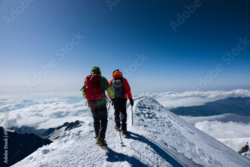Obraz na plátně A Life Happens Outdoors rope party descending the Mont Blanc summit ridge in clear blue sky weather, capturing precision, teamwork, and classic alpine exposure in the French Alps