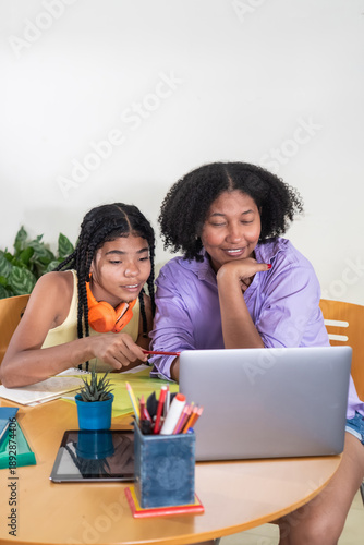 Mother and daughter learning together using laptop at home