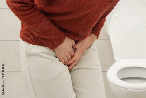 Woman Experiencing Lower Abdominal and Bladder Pain in Bathroom – Urinary Tract Infection, Cystitis, Cramps and Digestive Discomfort Concept