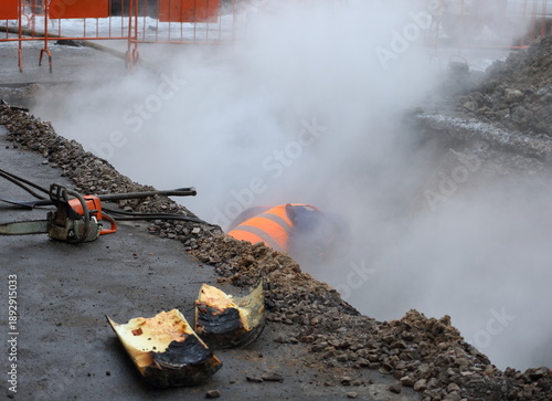 A repair worker fixes a break in a heating system