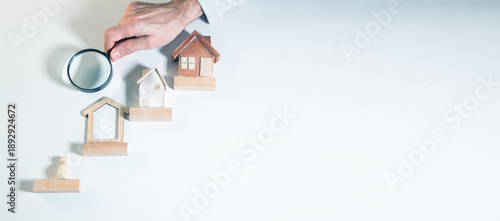 Mortgage concept by house from wooden blocks and magnifying glass