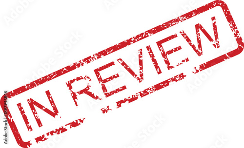 Red rubber stamp with the text 'IN REVIEW' clearly imprinted on a white background, symbolizing a process of examination or assessment
