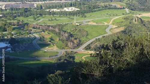 Scenic, high-angle panoramic view of the famous Forest Lawn Memorial Park in Glendale, California, with its green hills, church, and winding roads.