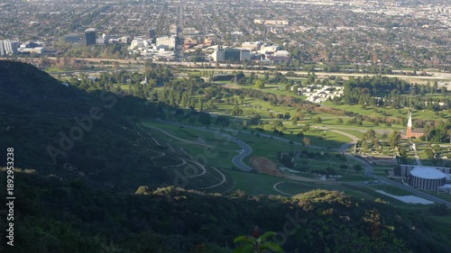 Scenic, high-angle pan from left to right, revealing the famous Forest Lawn Memorial Park in Glendale, California, with its green hills and church.