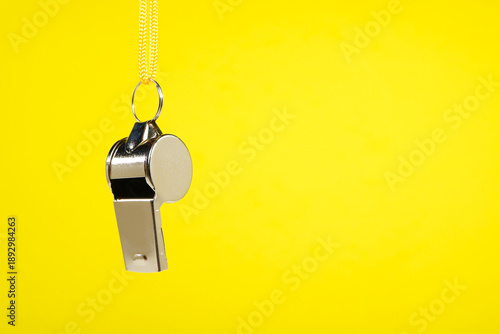 Εκτύπωση καμβά Silver metal referee whistle with bright yellow lanyard hanging isolated against