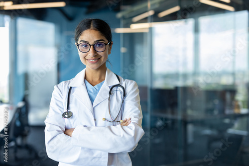 Valokuva Portrait of a young Indian female doctor standing in a white coat and glasses in
