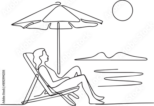 Woman relaxing on beach chair under umbrella by the sea
