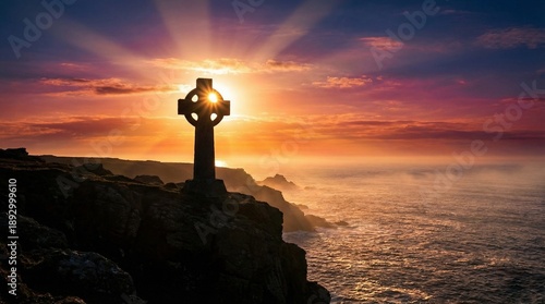 Celtic cross overlooking the ocean at sunset with vibrant colors  