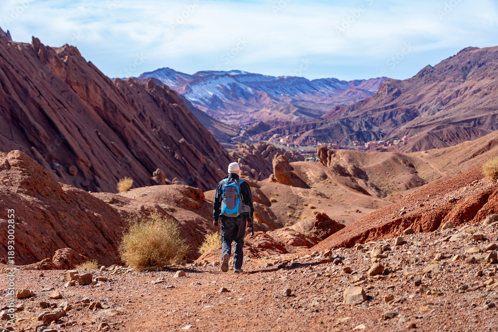 Fototapeta premium Wanderreise, Urlaub in Marokko, Dades Tal, Dades Schlucht: Wanderung im Canyon nahe der Felsen - Monkey Fingers, Pattes Des Singes: Mann, Wanderer in spektakuläre Landschaft mit roten Bergen
