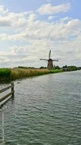 Scenic view of a traditional historic windmill by the canal in Kinderdijk, Netherlands