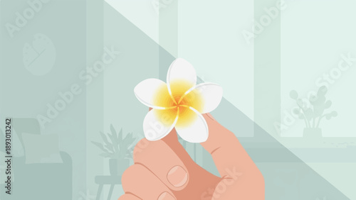 A hand holds a delicate white flower with a yellow center