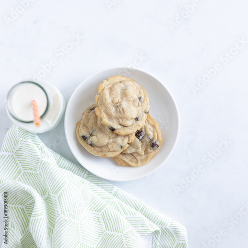 cookie on a plate with glass of milk