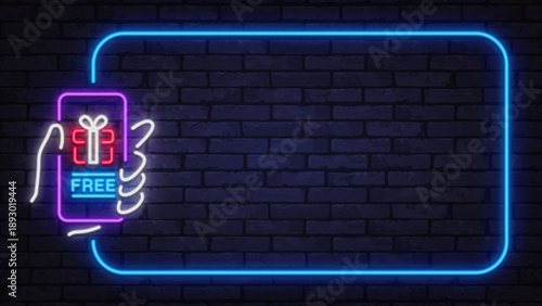 Neon smartphone with free gift message and glowing frame on dark wall. Promotional concept perfect for giveaways, bonus offers, or digital marketing visuals.