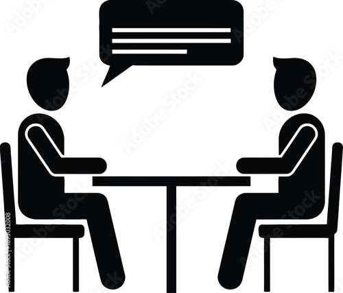 Two people sitting at a table having a conversation