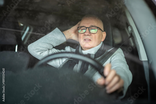 Fotografija Stressed man driving car experiencing headache and frustration
