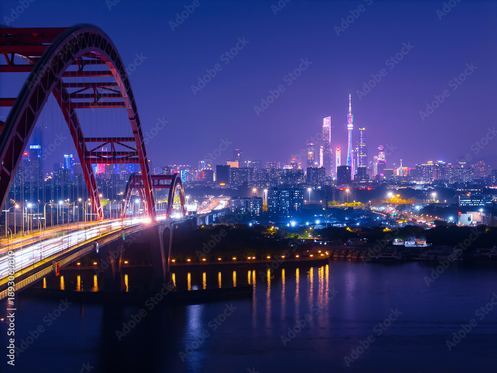 Naklejka premium Stunning aerial view of Guangzhou Guangdong China at night with illuminated skyline and bridge