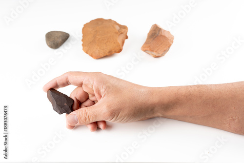 Tableau sur toile Hand holding Paleolithic stone arrowhead found in Algerian Sahara with prehistor