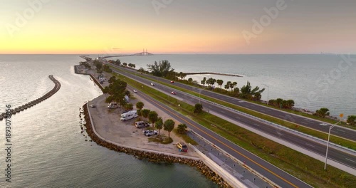 RV campers parked at sunset near Sunshine Skyway Bridge over Tampa Bay in Florida. Transportation infrastructure in America.