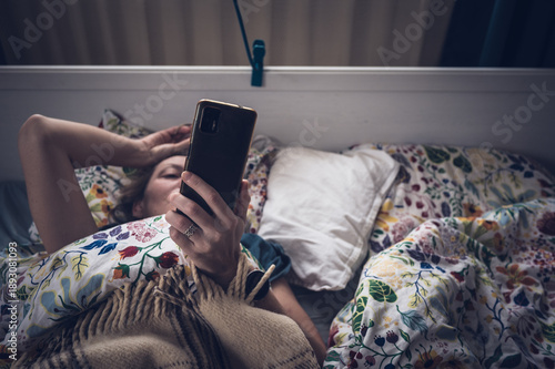 Woman Using Smartphone in Bed at Night