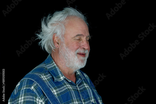 Obraz na plátne Character-rich portrait of an elderly man with wild white hair and beard, eyes closed in a peaceful moment
