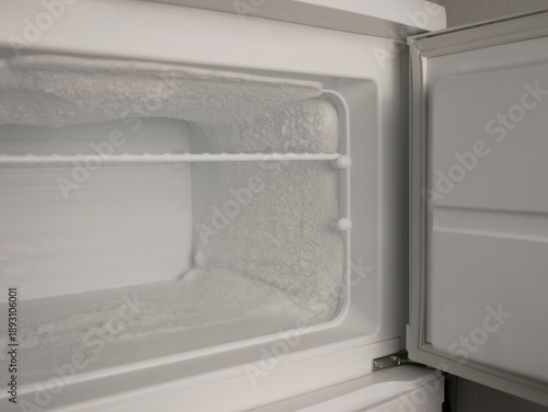 Empty freezer with heavy frost and ice buildup. Cold storage concept, refrigeration problem, defrost need, appliance maintenance, food safety, copy space
