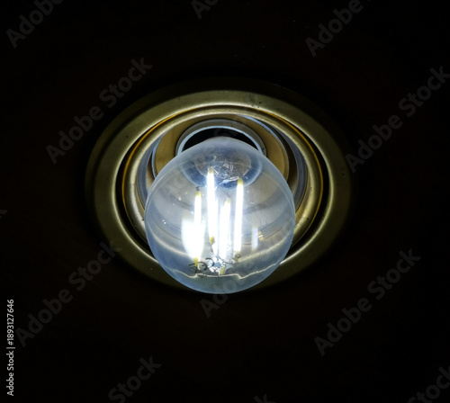 Lampadina led accesa con filamenti incandescenti in portalampade color ottone