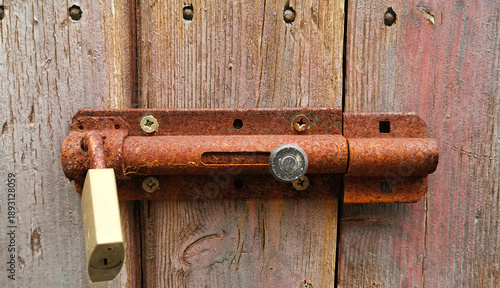 Vecchio catello arrugginito con lucchetto su vecchia porta di legno