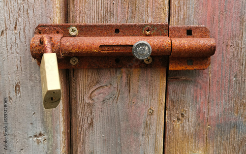 Vecchio catello arrugginito con lucchetto su vecchia porta di legno
