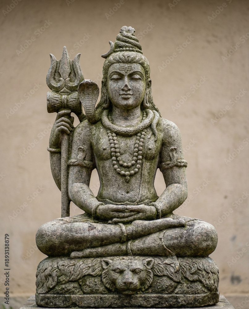 Fototapeta premium Stone Statue of Lord Shiva Meditating with Trident and Cobra