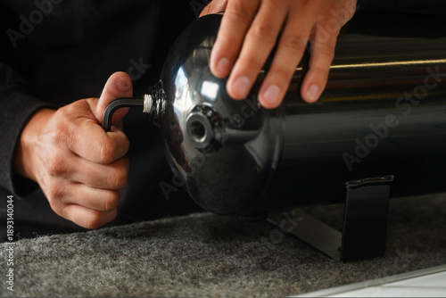 Technician Installing Industrial Metal Cylinder with Hand Tool