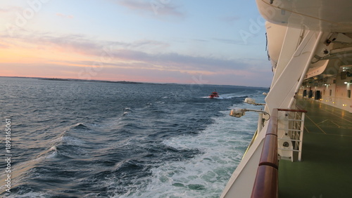 Lotse im Lotsenboot fährt bei rauer See zu einem Kreuzfahrtschiff. Maritime Sicherheit, Schifffahrt und Navigation auf offener See. Dynamische Szene mit Wellen, Technik und professioneller Seefahrt.