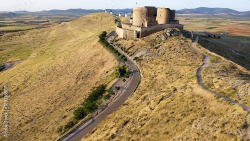Aerial view of sunrise over the Medieval Castle of Consuegra and his windmills in Toledo, Spain.