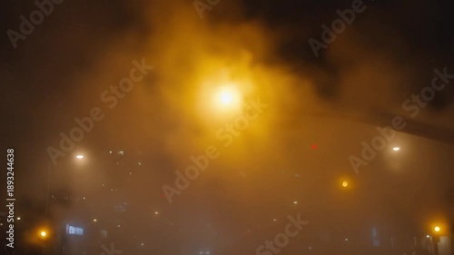 Nighttime scene with a bright light shining through smoke or fog amidst city lights at night.