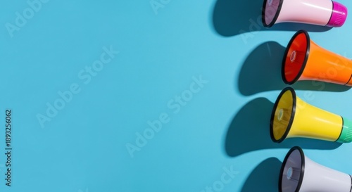 Colorful megaphones with hard shadows on bright blue background