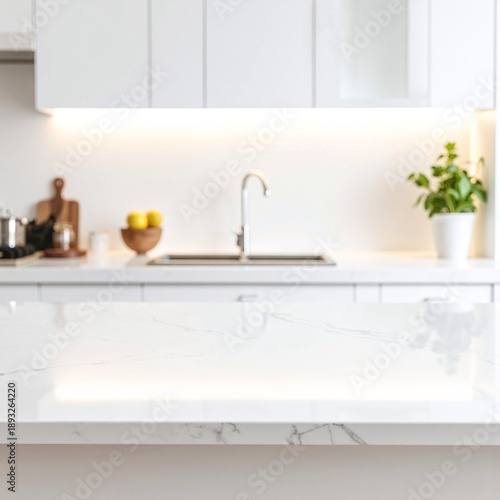 Bright white kitchen with sleek cabinetry, marble countertops, stainless fixtures, and soft natural light illuminating a clean, modern space