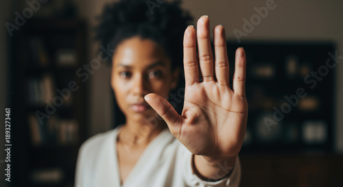 Serious Black woman holding hand out in stop gesture for mental health, trauma, and domestic abuse prevention concept.