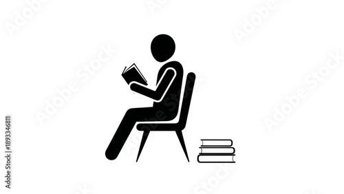 Person sitting on chair reading a book with stack of books nearby.