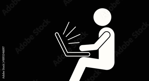 Person sitting and using a laptop computer screen glowing brightly.