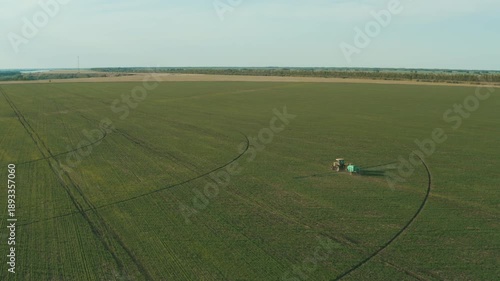 An aerial view of a self-propelled sprayer operating on a vast agricultural field. Precise crop treatment helps effectively protect plants, optimize chemical use, and increase yields.