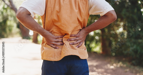 Valokuva Man, hands and fitness in forest with back pain, muscle spasm and hiking injury