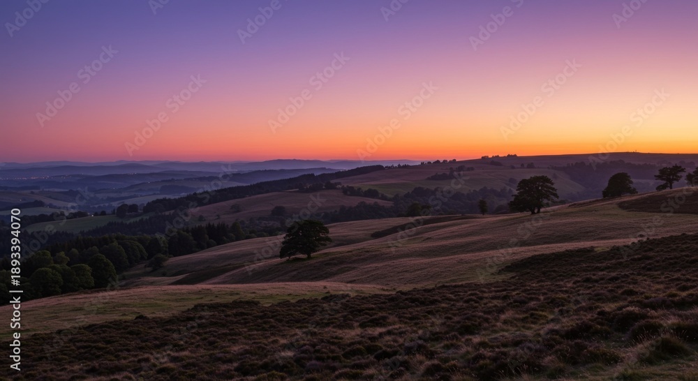 Fototapeta premium Vibrant Sunset Over Rolling Hills and Fields