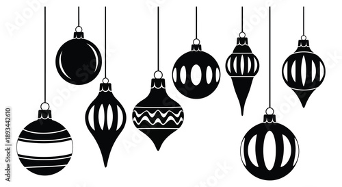 Black christmas ornaments hanging from above a striking decorative silhouette