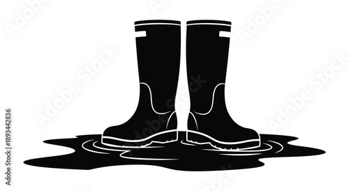 Pair of black rubber boots standing in a puddle minimalist silhouette