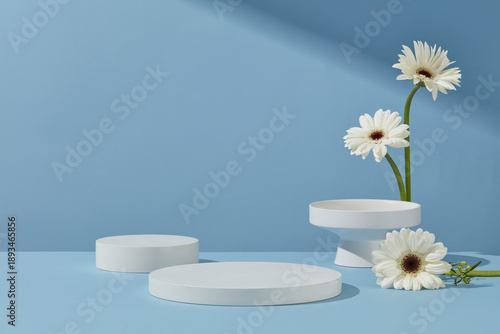 Fotografi Multiple round white podiums arranged on a pastel blue surface with floral accen