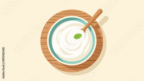 Creamy yogurt in a bowl with a wooden spoon and mint leaf