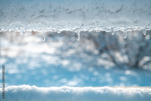Valokuva Accumulation of snow and ice coating a surface, with icicles starting to melt an