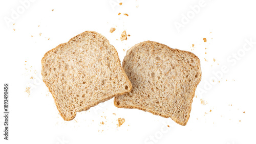 Cutting slices of wholegrain wheat bread with crumbs flying isolated on white background. Toast bread pieces.